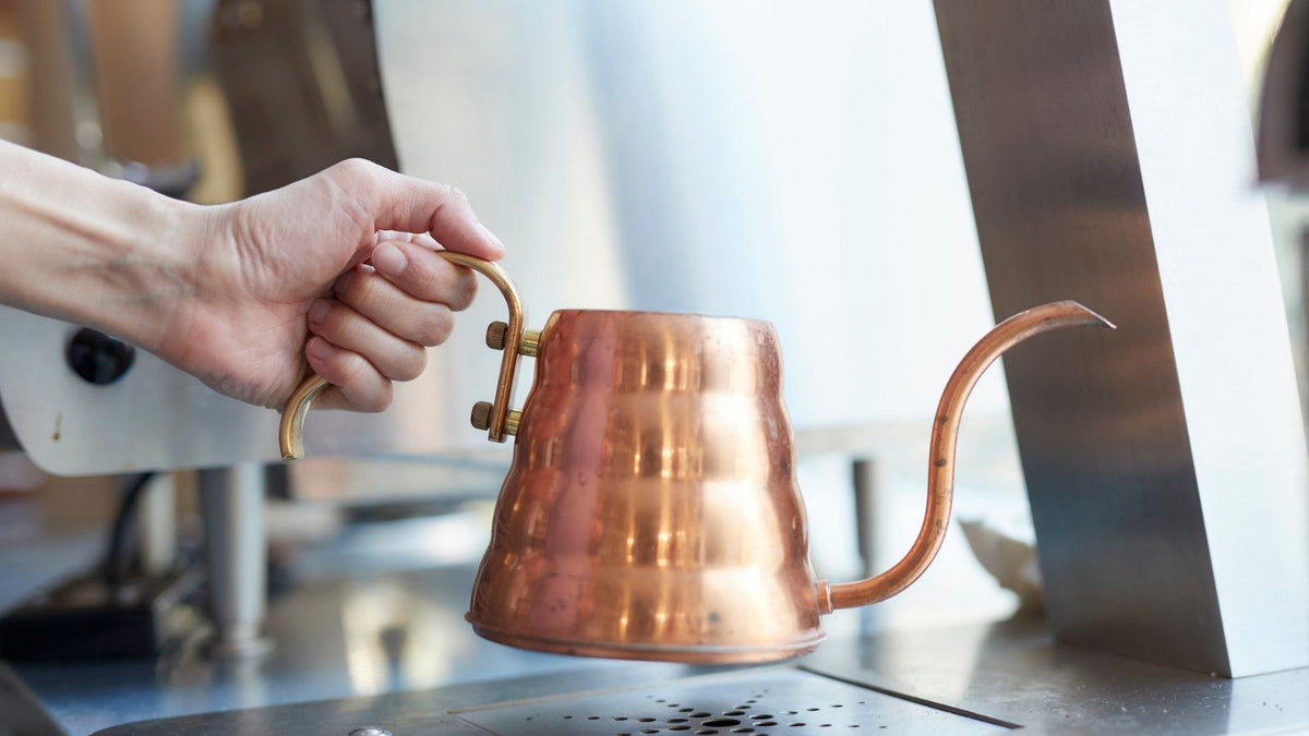 Woman holding a copper tea pot