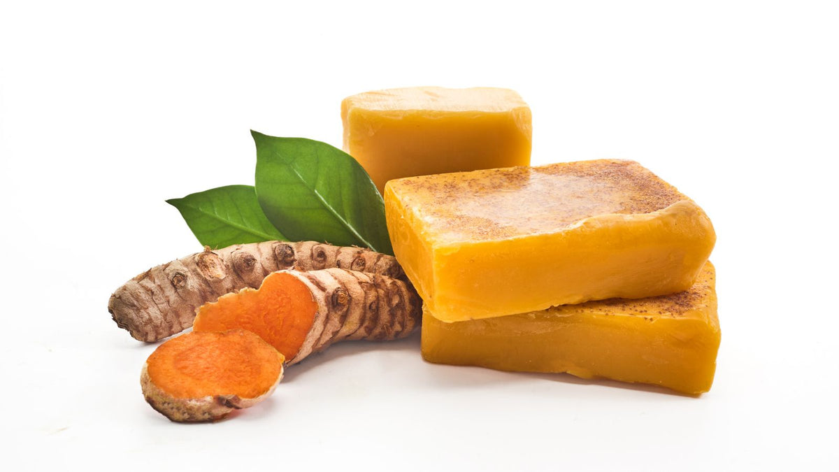 turmeric soap and root on a white surface