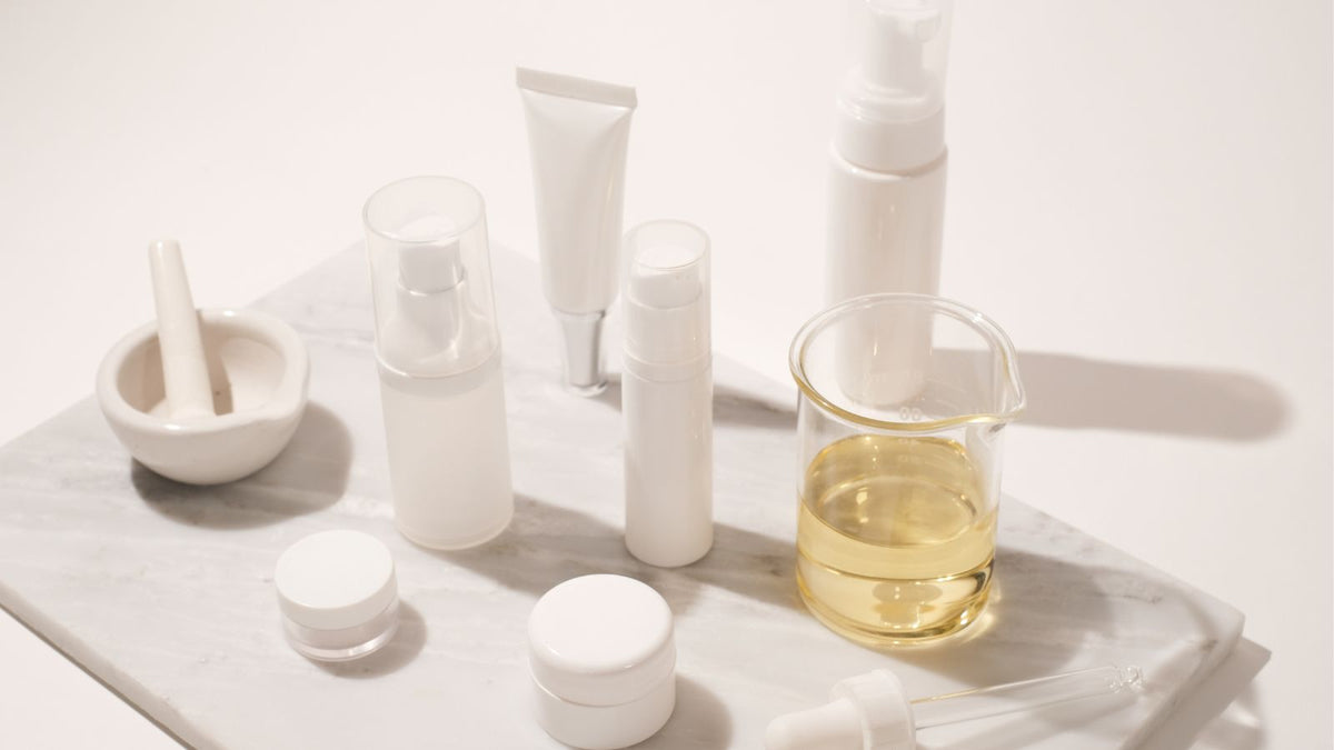 A stylized shot of un-labled skincare with a beaker of un-labled chemicals