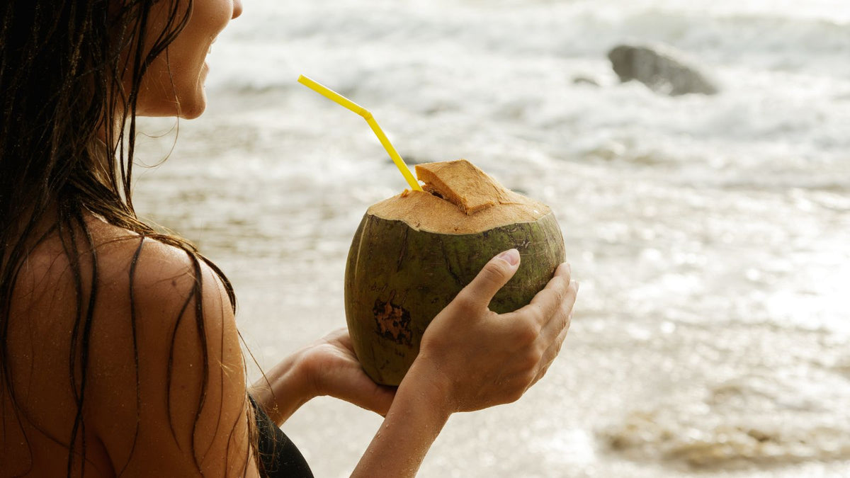 a woman drinking from a coconut