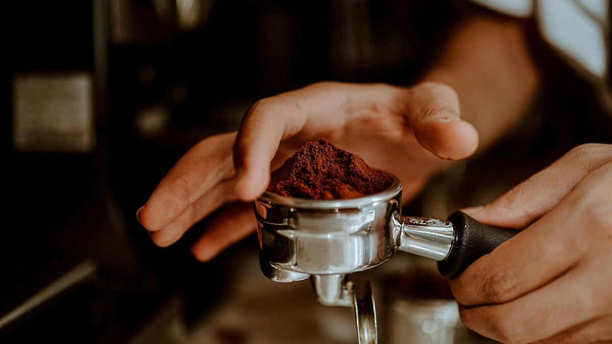 barista scraping coffee grinds with hands