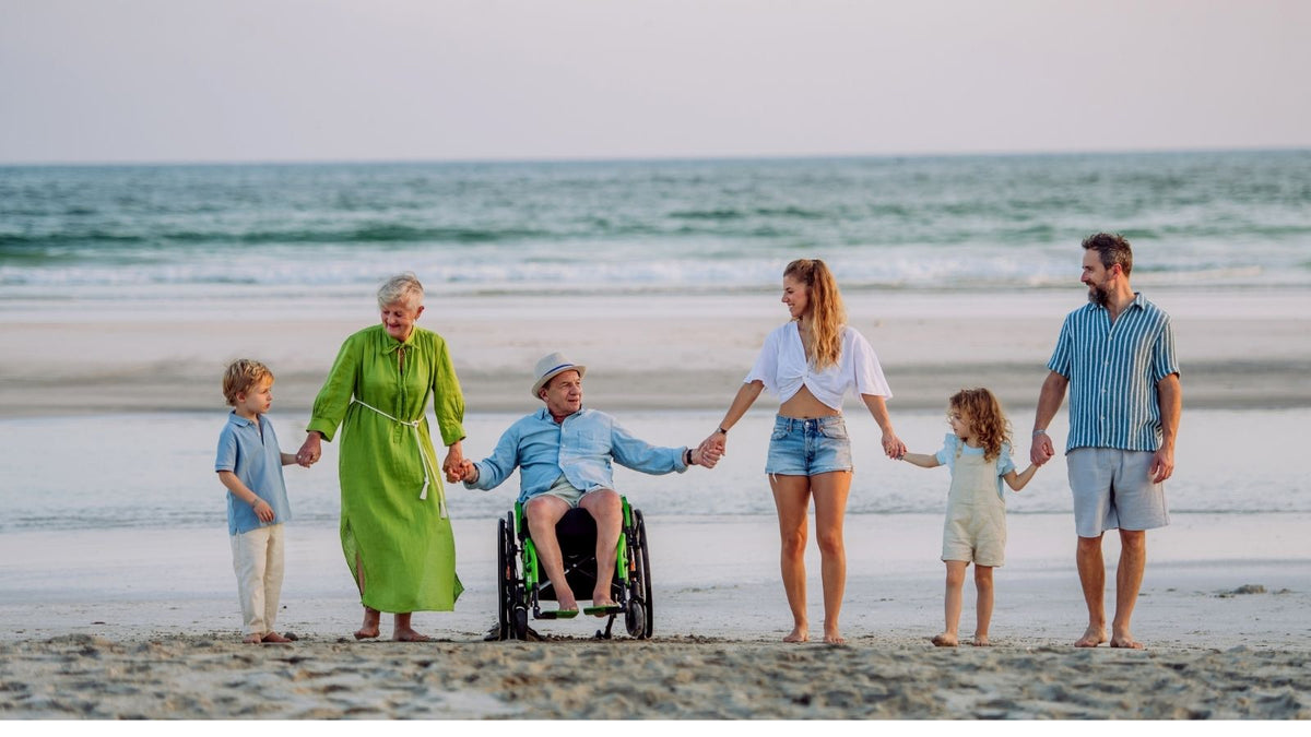 multigenerational family holding hands on the beach