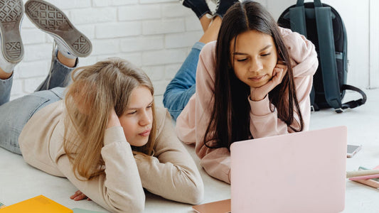 Two teen girls researching on a computer