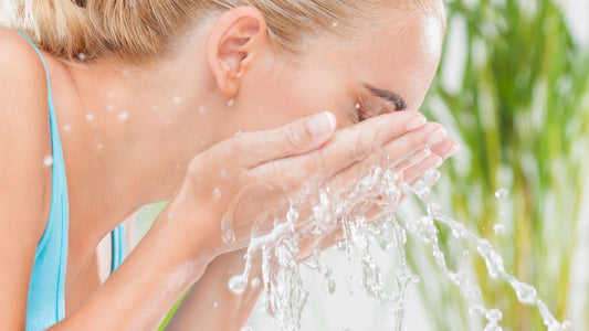 woman washing her face with the functional skincare ingredient water