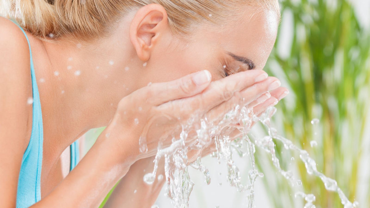 woman washing her face with the functional skincare ingredient water