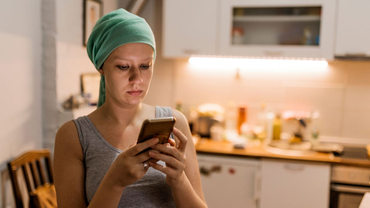 cancer patient reading her phone at night