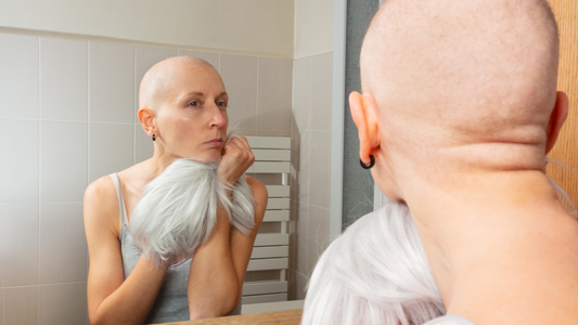 chemo patient lookin at herself in mirror