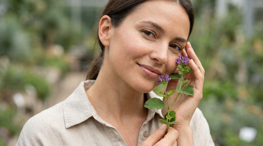 A woman holding bakuchiol close to her face