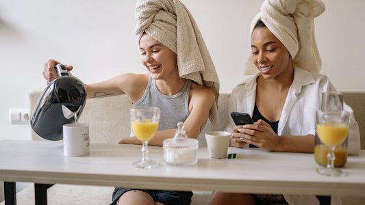 Two woman with hair in towels having morning tea and orange juice